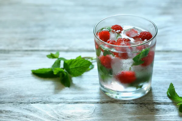 Copa de refrescante bebida fría de verano con bayas y cubitos de hielo en la mesa de cerca —  Fotos de Stock