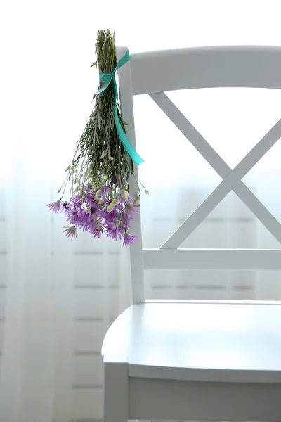 Bukiet kwiatów dzikiego suszenia na krzesło na jasnym tle — Zdjęcie stockowe