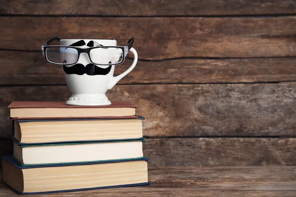 Vintage books och cup med mustasch på trä bakgrund — Stockfoto