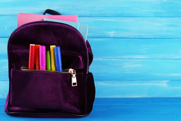 Рюкзак з шкільними приладдям на дерев'яному фоні — стокове фото