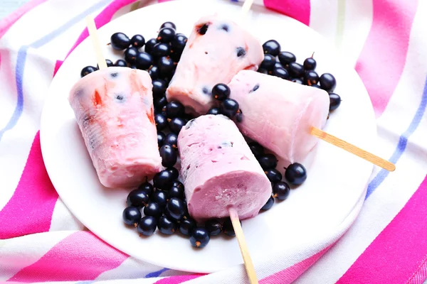 Sweet ice cream with black currants in white plate on striped napkin, closeup — Stock Photo, Image