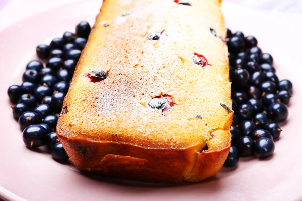 Frisch gebackener Kuchen mit schwarzen Johannisbeeren in rosa Teller, Nahaufnahme — Stockfoto