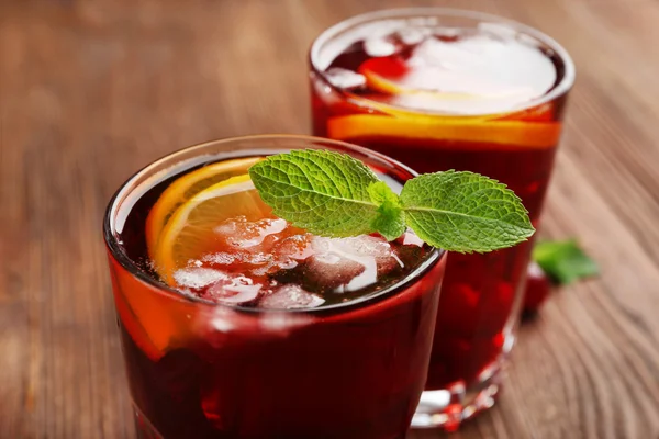 Vasos de jugo de cereza sobre fondo de madera — Foto de Stock