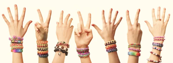 Manos de la gente con braceles sobre fondo claro —  Fotos de Stock