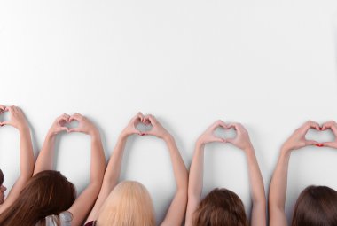 Gençler yapar ışık arka plan üzerinde parmaklarını kullanarak Kalpler