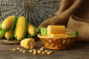 Taze mısır koçanı hasır kase tutuyordu, closeup ahşap tablo