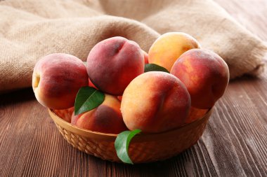 Hasır sepet üzerinde ahşap masa, tatlı taze şeftali