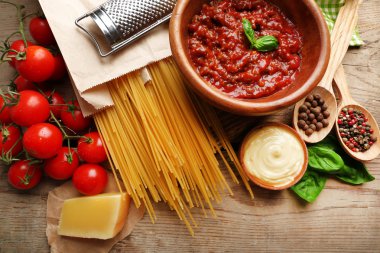 Makarna spagetti domates, sos bolognese, peynir ve fesleğen rustik ahşap zemin üzerine