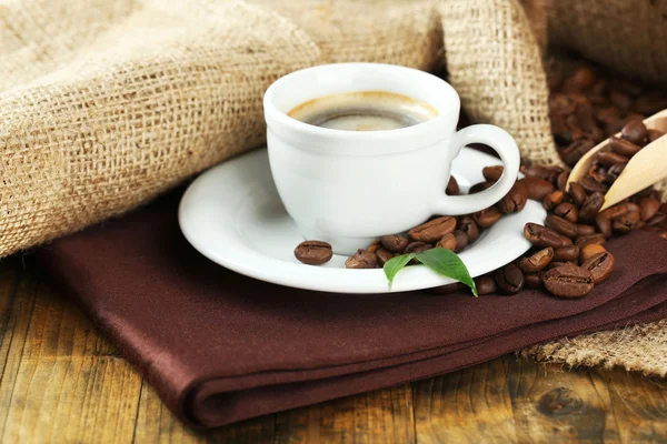 Чашка кофе с фасолью на столе — стоковое фото