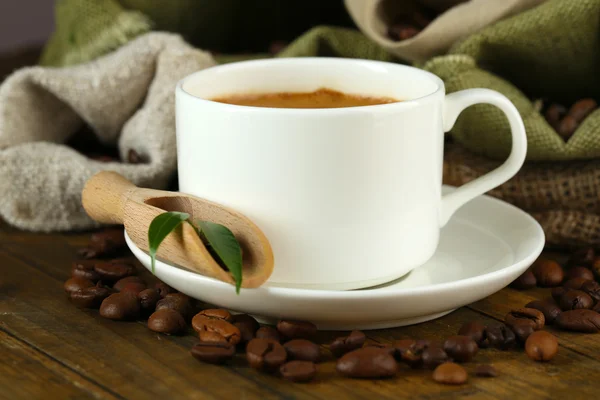 Tazza di caffè con fagioli in tavola da vicino — Foto Stock