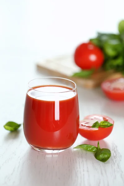 Jugo de tomate y tomates frescos en primer plano de mesa de madera — Foto de Stock