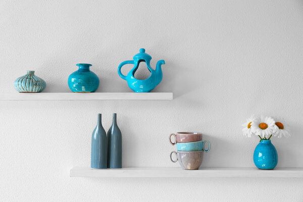 Decorative vases on wooden shelf