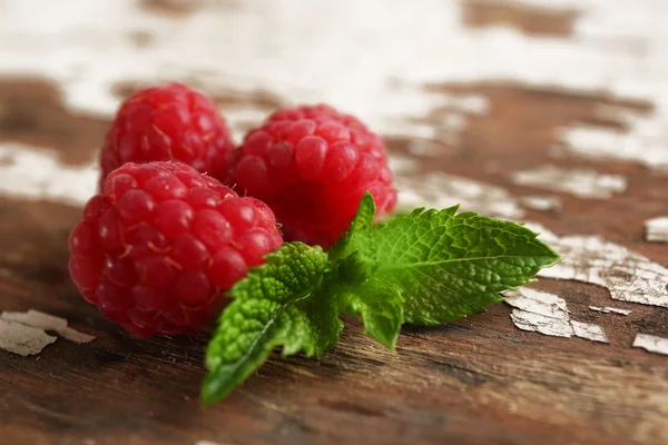 Čerstvé červené maliny na rustikální dřevěný stůl, detail — Stock fotografie