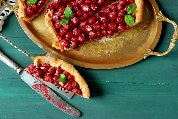 Piece of tart with raspberries on tray, close-up, on color wooden background — Stock Photo, Image