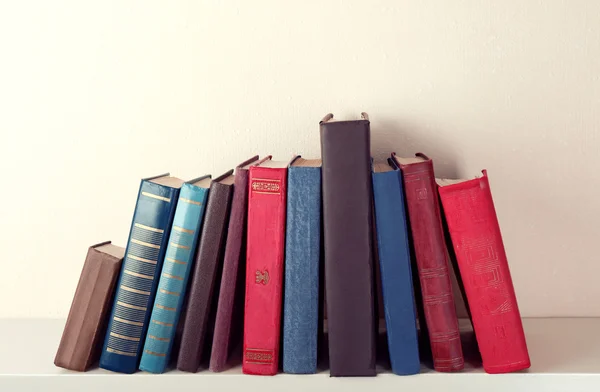 Oude boeken op plank, close-up, op lichte muur achtergrond — Stockfoto