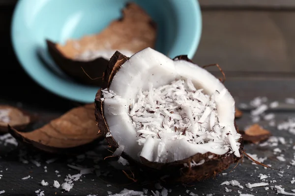 Aparas de coco em coco sobre fundo de madeira — Fotografia de Stock