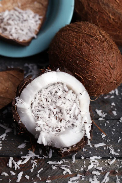 Coconut shavings in coconut on wooden background — Stock Photo, Image