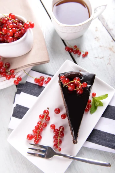 Gâteau au chocolat savoureux avec des baies et une tasse de thé sur la table close up — Photo