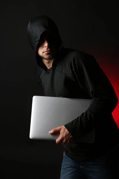 Hacker com computador e laptop sobre fundo escuro colorido — Fotografia de Stock