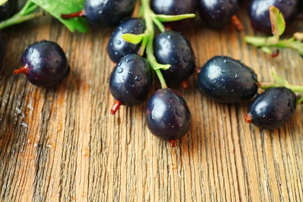 Högen av svarta vinbär på träbord, närbild — Stockfoto