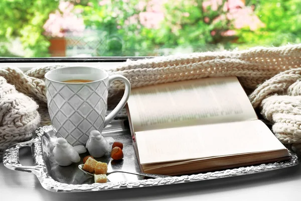 Xícara de chá com livro sobre bandeja de metal, close-up — Fotografia de Stock
