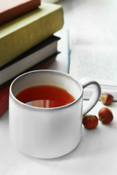 Xícara de chá com pilha de livros no peitoril da janela, close-up — Fotografia de Stock