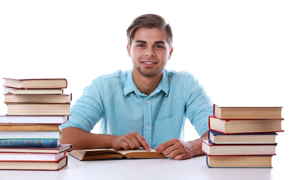 Joven leyendo libro en la mesa sobre fondo blanco — Foto de Stock