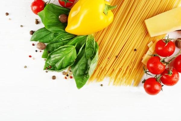 Makarna spagetti domates, peynir ve renk ahşap arka plan üzerinde fesleğen ile — Stok fotoğraf