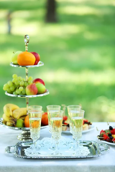 Snacks, fruits and drinks on table, outdoors. Garden party concept — Stock Photo, Image