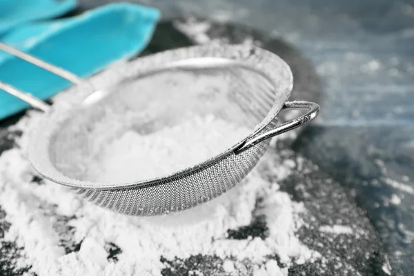 Sifting flour through sieve on wooden table, closeup — Stock Photo, Image