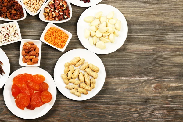 Different products on saucers on wooden table, top view — Stock Photo, Image