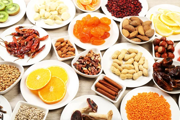 Different products on saucers on wooden table, closeup — Stock Photo, Image