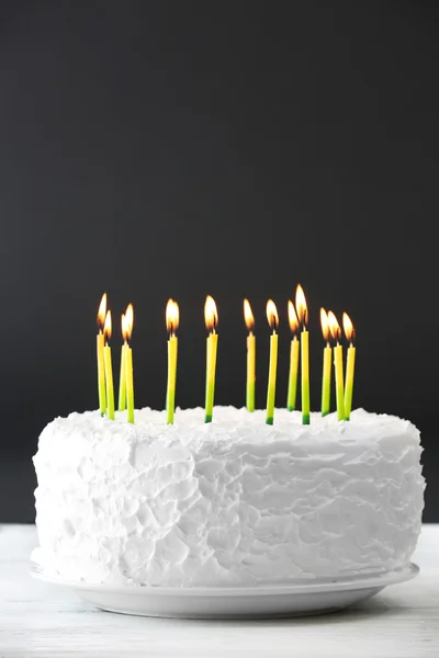 Verjaardagscake met kaarsen op donkere achtergrond — Stockfoto
