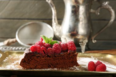 Çikolata sır ve ahududu ahşap arka plan üzerinde tepsi ile çok kolay