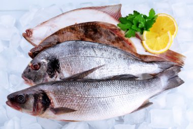 Buz arka plan üzerinde limonlu taze balıklar