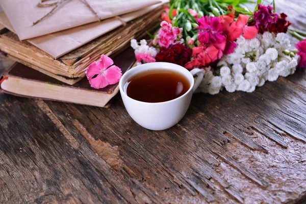 Oude boeken met bloemen en kopje thee — Stockfoto
