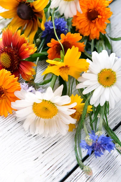 Flores silvestres brilhantes na mesa de madeira, close-up — Fotografia de Stock