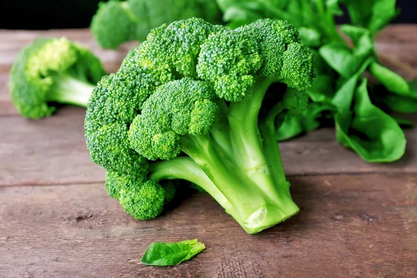 Brócoli fresco con espinacas en la mesa de madera de cerca — Foto de Stock