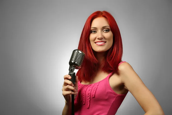 Beautiful young woman with microphone — Stock Photo, Image