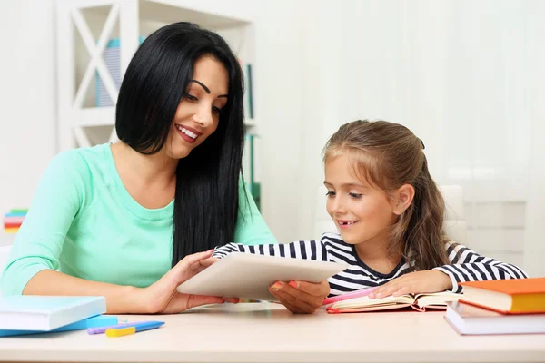 Scuola ragazza facendo i compiti con la madre — Foto Stock