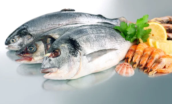 Свежие рыбы и креветки со специями на металлическом фоне — стоковое фото