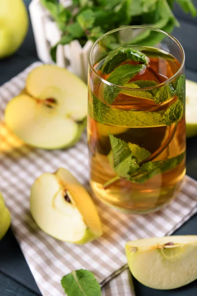 Glass of apple juice with fruits and fresh mint on table close up — Stock Photo, Image