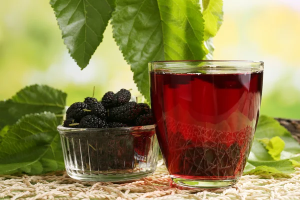 Стакан освежающего тутового сока с ягодами на ярком фоне — стоковое фото