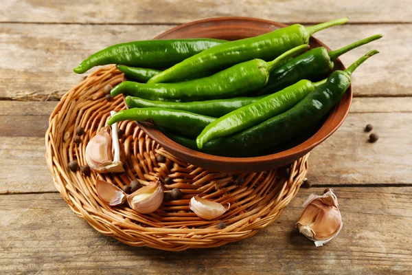 Groene hete pepers met knoflook op houten tafel close-up — Stockfoto