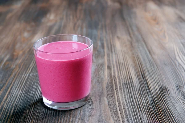 Glass of raspberry milk shake on wooden background — Stock Photo, Image