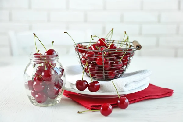 Cherries in basket on table, on light background — Stock Photo, Image