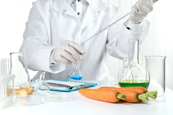 Cientista examina cenouras em laboratório — Fotografia de Stock