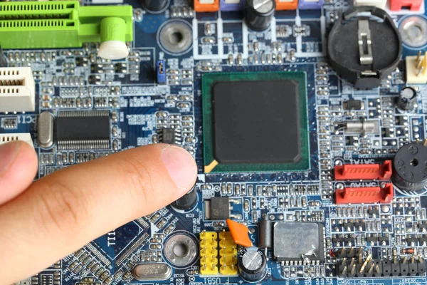 Finger points to motherboard — Stock Photo, Image