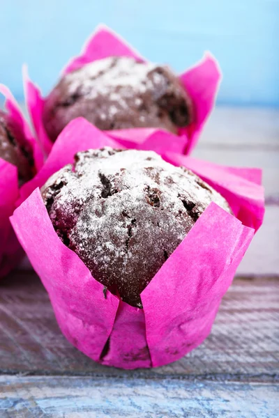 A rózsaszín papírt a fából készült asztal, Vértes csokoládé cupcakes — Stock Fotó
