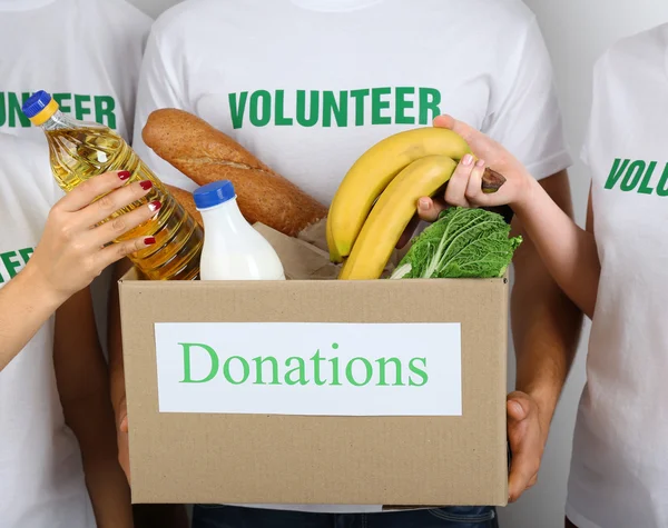 Доброволец держит коробку для пожертвований с едой — стоковое фото